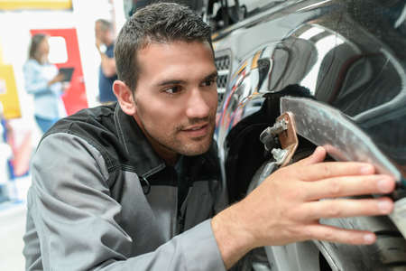 Car body worker repairs domage on a carの写真素材