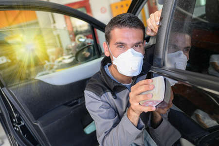 Car body worker polishes the car before his deleveryの写真素材