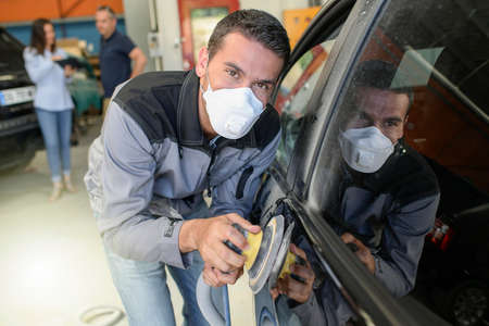 Car body worker polishes the car before his deleveryの写真素材
