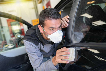 Car body worker polishes the car before his deleveryの写真素材