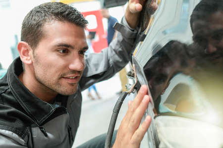 Car body worker repairs domage on a carの写真素材