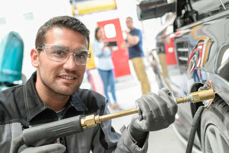 Car body worker repairs domage on a carの写真素材