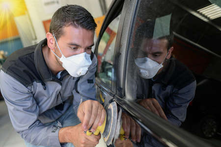 Car body worker polishes the car before his deleveryの写真素材