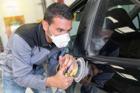 Car body worker polishes the car before his deleveryの写真素材