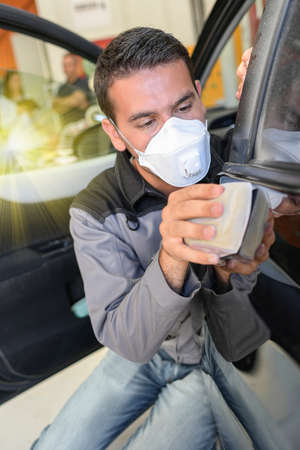 Car body worker polishes the car before his deleveryの写真素材