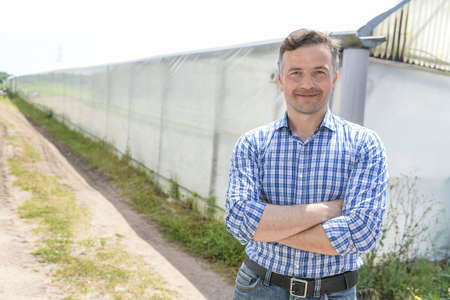 Young male farmer in front of a greenhouseの写真素材