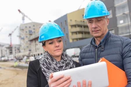 Construction manager and architect reading their notes on a siteの写真素材