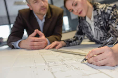 Close-up of the hand of a female architect drawing over a blueprintの写真素材