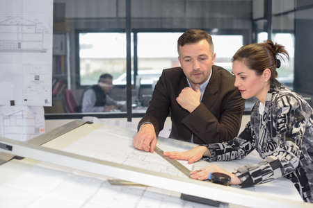 Supervisor checks her female architect assistant's workの写真素材