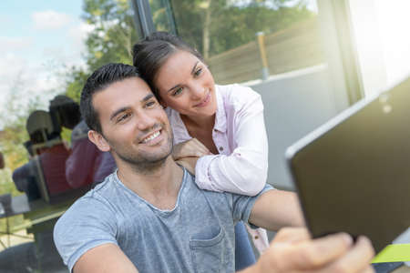 Couple on video call with a tablet outdoorsの写真素材