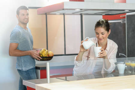 Happy young couple is ready to have breakfast at homeの写真素材