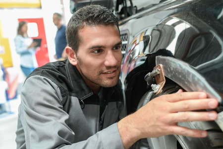 Car body worker repairs domage on a carの写真素材