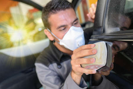 Car body worker polishes the car before his deleveryの写真素材