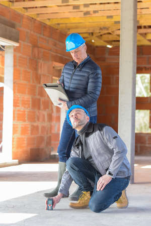 Architect is supervising the measurements in a construction siteの写真素材