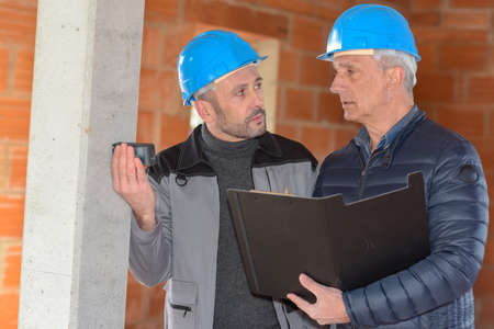 Architect is supervising the measurements in a construction siteの写真素材