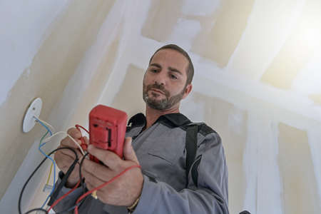 the electrician checks the electrical installation of a house and searches for the electrical failureの写真素材