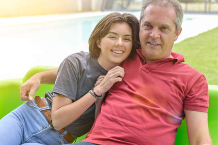 Portrait of a father and his accomplice daughter sitting in their gardenの写真素材