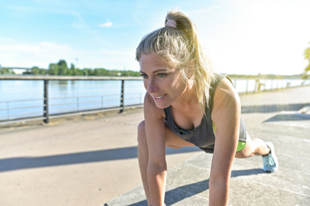 young woman doing her stretching after her joggingの写真素材