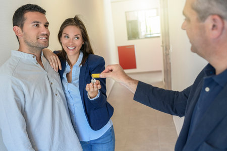 young couple happy to buy their first home at a real estate agentの写真素材