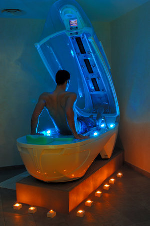 Man installed in solarium equipment to improve his tanの写真素材