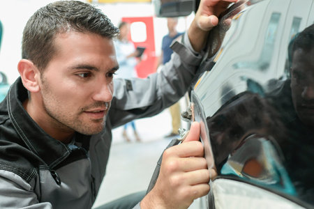 Car body worker repairs domage on a carの写真素材