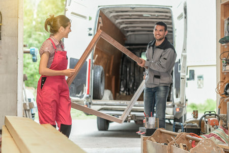 Carpenters unload their van in the workshopの写真素材