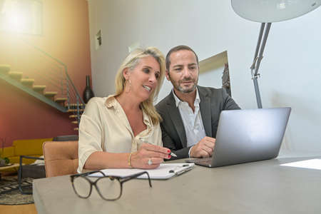 Colleagues work together on a project in front of the computer from a private homeの写真素材