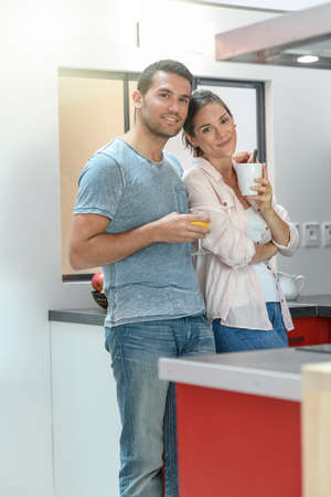 Happy young couple is ready to have breakfast at homeの写真素材