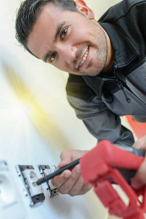 Electrician working on electric socketの写真素材
