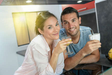 young couple have a quick breakfast in the kitchenの写真素材