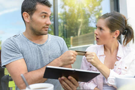 Happy couple using a tablet and paying onlineの写真素材