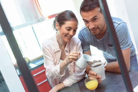 young couple have a quick breakfast in the kitchenの写真素材