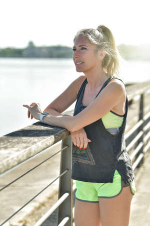 Female runner during her running session along a river in the cityの写真素材
