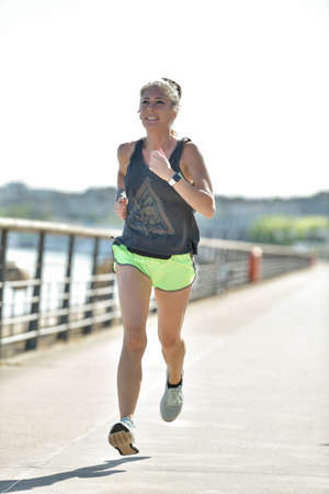 Athlectic woman during her running cession along the river in the cityの写真素材