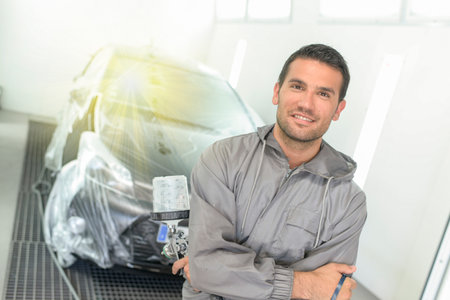 Car body worker polishes the car before his deleveryの写真素材