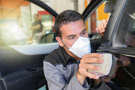 Car body worker polishes the car before his deleveryの写真素材