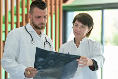 Discussion between two doctor colleagues about a patient's X-rayの写真素材