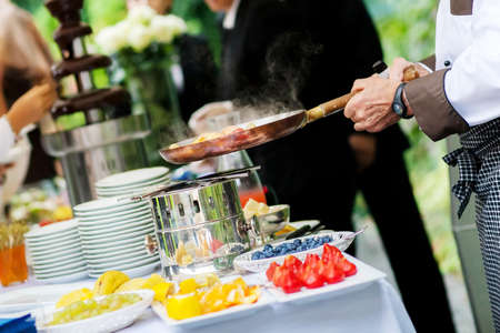 Catering event chef is cooking fruit