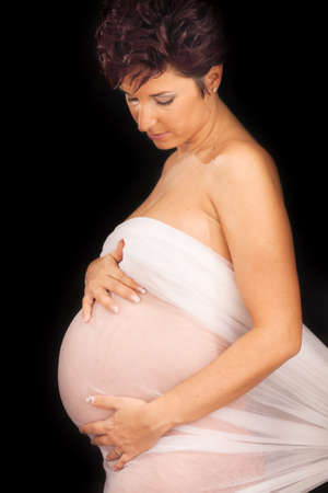A maternity portrait of a woman at eight months along in her pregnancy の写真素材