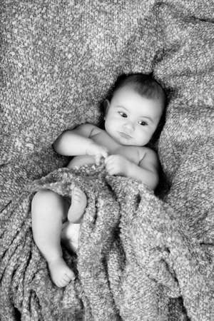 Baby boy reclining on brown blanketの写真素材