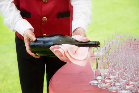 Waiter pouring  champagne on a partyの写真素材