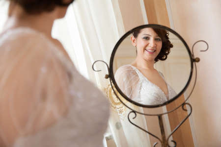 bride smiles in front of the mirrorの写真素材