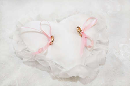 two gold wedding rings on the pincushionの写真素材