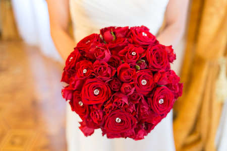 bride holding bouquet of red rosesの写真素材