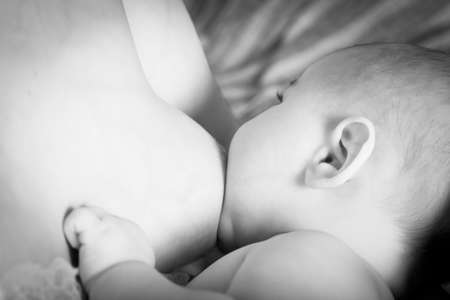 Young mother breastfeeds her baby.