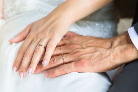 bride and groom hands with wedding ringsの写真素材