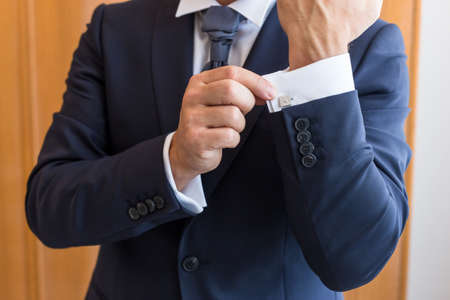 The man in the white shirt and cufflinks.