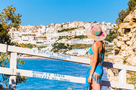 Woman in bikini admires the splendid panorama of Peschici, old town in Apulia region, south Italyの写真素材