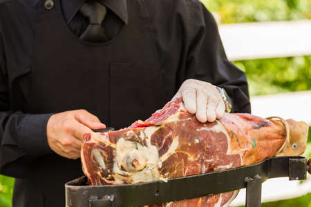 Waiter slicing ham, prosciuttoの写真素材