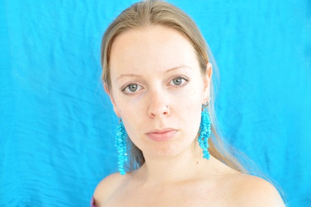 young woman on turquoise background woth young woman on turquoise background earringsの写真素材
